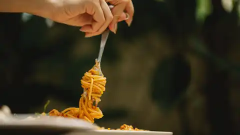 Persona comiendo un plato de espaguetis