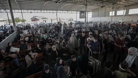 Palestinos que esperan cruzar por el paso de Rafah