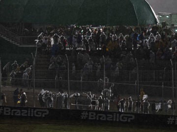 Aficionados se protegen de la lluvia en el GP de Brasil 