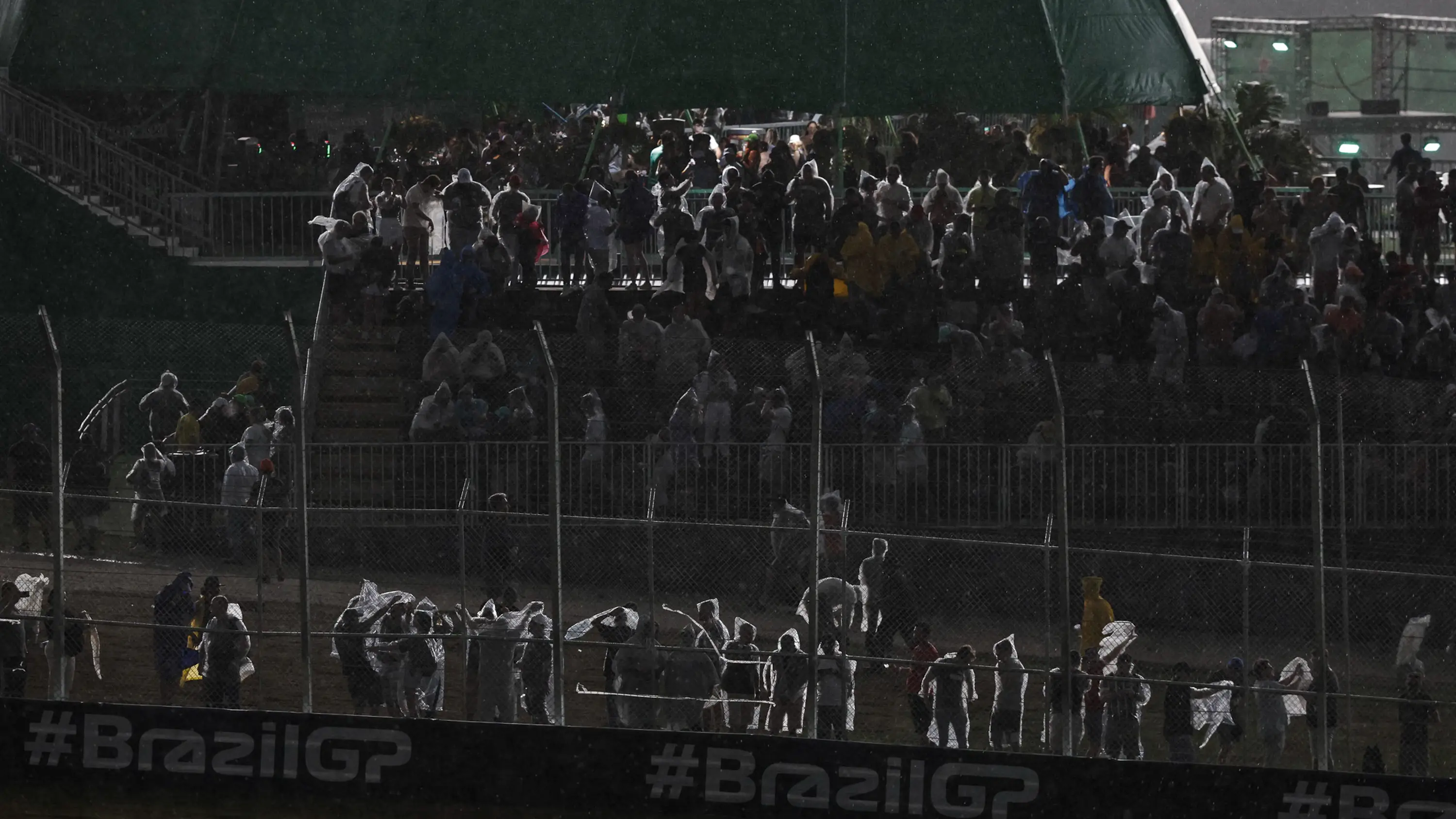 Aficionados se protegen de la lluvia en el GP de Brasil 