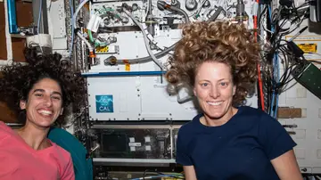 Los ingenieros de vuelo de la Expedición 70 (desde la izquierda) Jasmin Moghbeli y Loral O'Hara, ambos de la NASA, posan para un retrato frente al Laboratorio de Átomo Frío de la Estación Espacial Internacional.