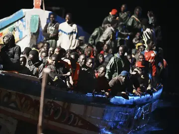 Decenas de personas en un cayuco a su llegada al muelle de La Restinga, en El Hierro Decenas de personas en un cayuco a su llegada al muelle de La Restinga, en El Hierro