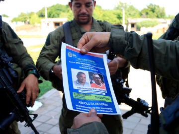 Un policía sostiene un cartel con la imagen de Luis Manuel Díaz, secuestrado por la guerrilla del ELN