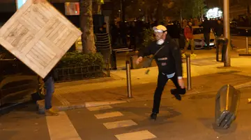 Un hombre lanza una caja entre las protestas de Ferraz