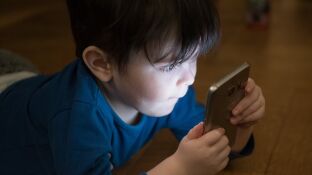 Imagen de un ni&ntilde;o viendo el m&oacute;vil
