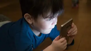 Imagen de un niño viendo el móvil Imagen de un niño viendo el móvil