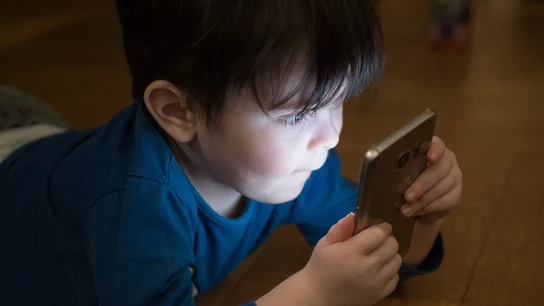 Imagen de un niño viendo el móvil Imagen de un niño viendo el móvil