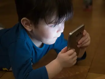 Imagen de un niño viendo el móvil Imagen de un niño viendo el móvil