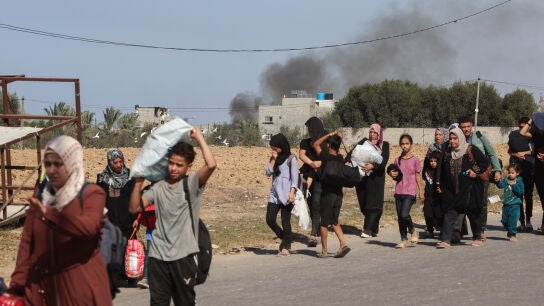 Familias palestinas que huyen de la ciudad de Gaza y otras partes del norte de Gaza hacia las zonas del sur, caminan por una carretera en medio de los continuos combates entre Israel y el movimiento palestino Ham&aacute;s.