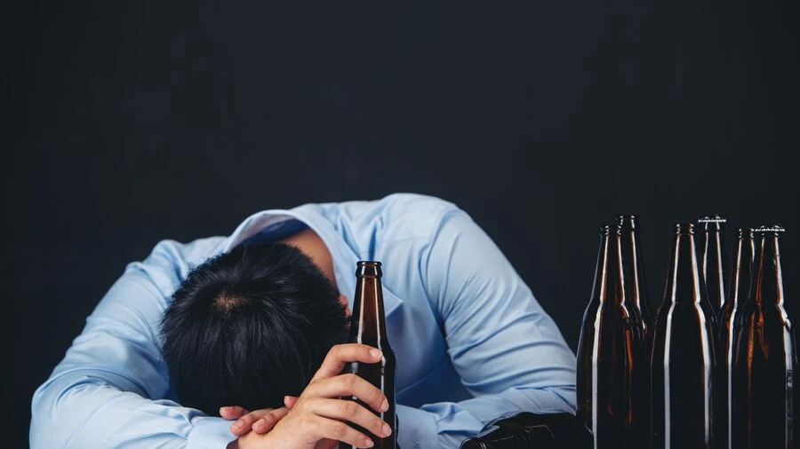 Hombre durmiendo con botellas de alcohol Hombre durmiendo con botellas de alcohol
