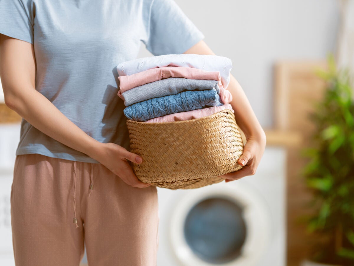 Basket of freshly folded laundry beside a washing machine