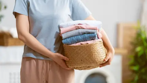 Una mujer con ropa limpia para guardar Una mujer con ropa limpia para guardar
