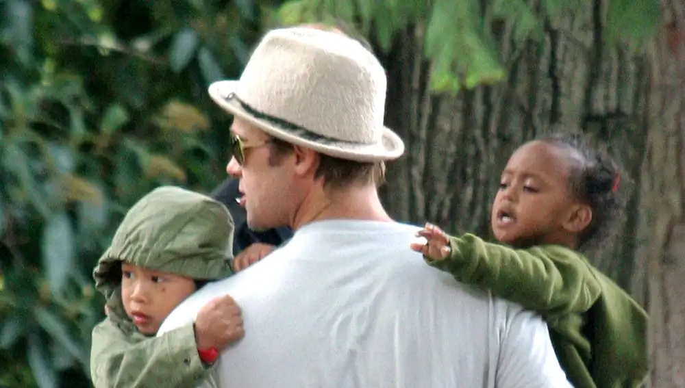 Brad Pitt con sus hijos Pax y Zahara Jolie en brazos