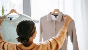 Una mujer revisa la ropa en perchas