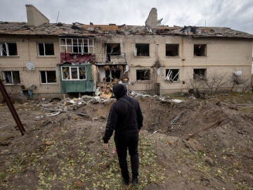 Un hombre observa el impacto de un misil ruso junto a un edificio de apartamentos
