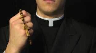 Sacerdote con sotana y rosario