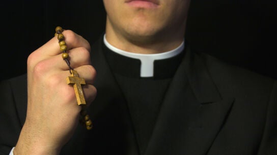Sacerdote con sotana y rosario