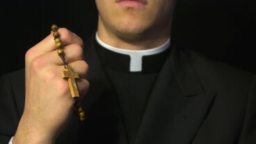 Sacerdote con sotana y rosario