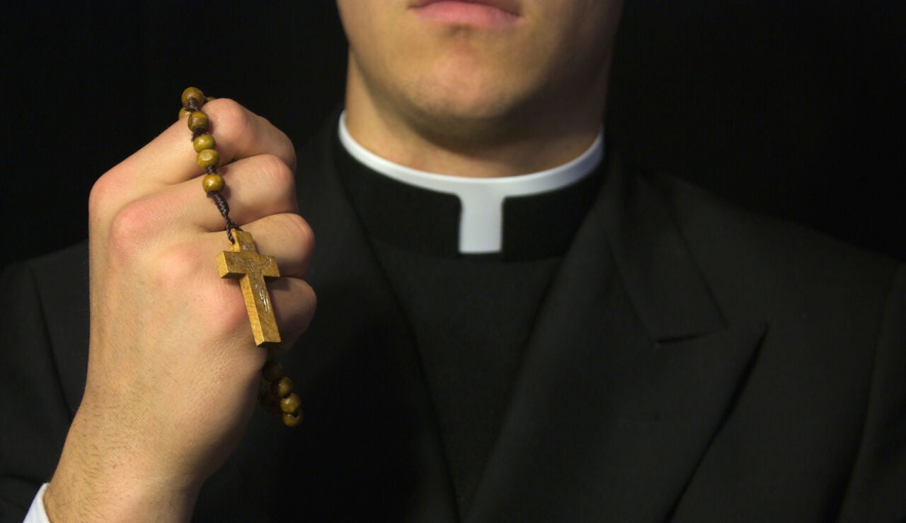 Sacerdote con sotana y rosario