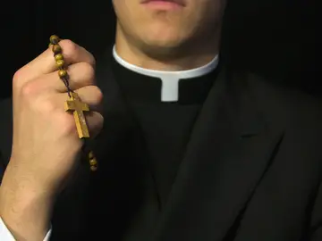 Sacerdote con sotana y rosario