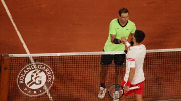 Rafa Nadal y Novak Djokovic se saludan tras un partido de Roland Garros en 2021