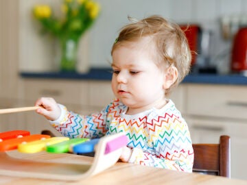 Un niño juega con un xilófono de juguete