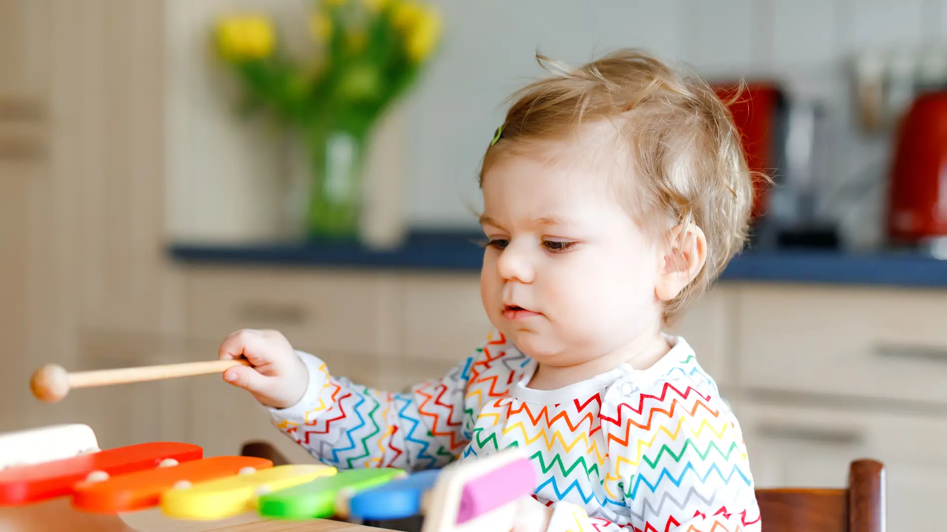 Un niño juega con un xilófono de juguete