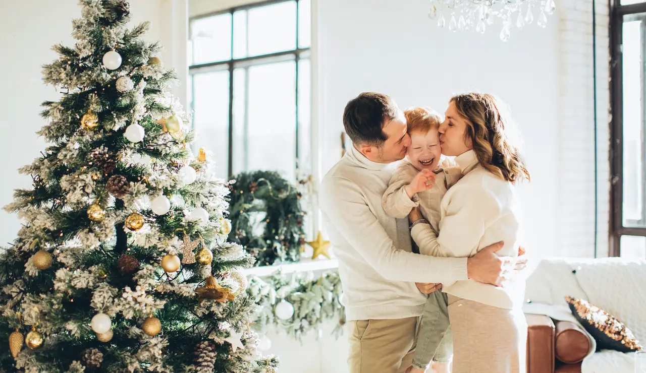 Una familia frente al árbol en Navidad