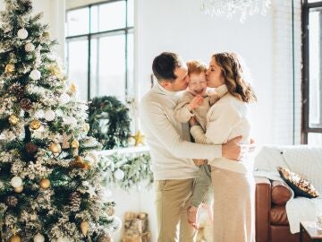 Una familia frente al árbol en Navidad