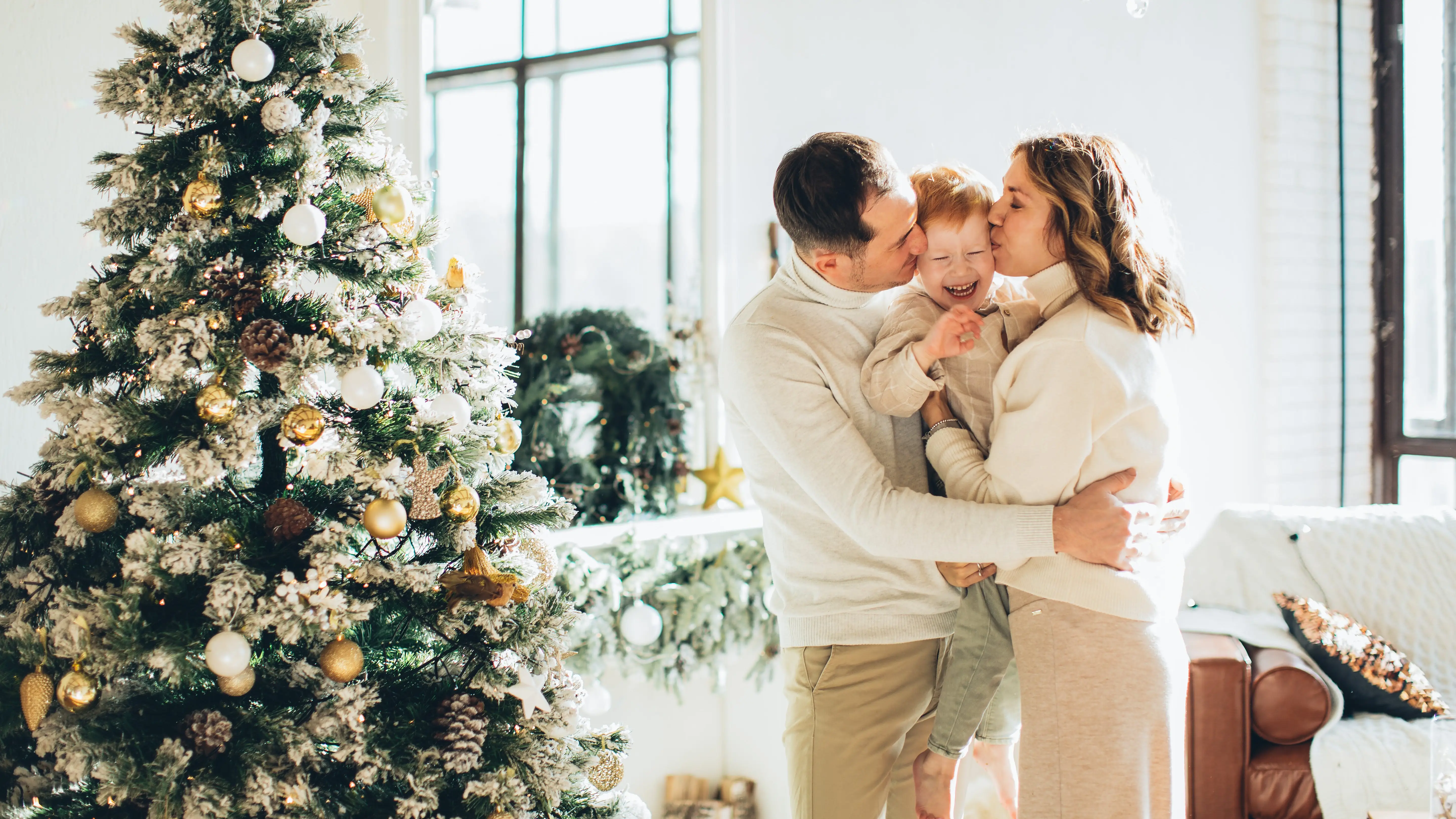 Una familia frente al &aacute;rbol en Navidad