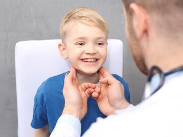 Médico examinando los ganglios a un niño