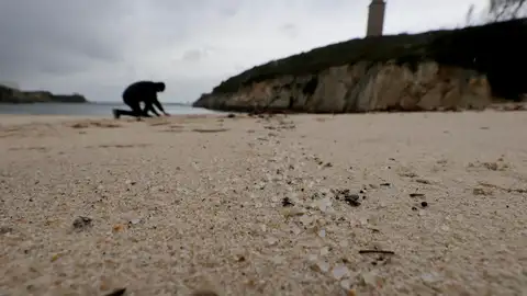Una persona recoge pellets en la playa de As Lapas Una persona recoge pellets en la playa de As Lapas