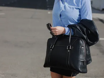 Mujer llevando un bolso grande de piel negro Mujer llevando un bolso grande de piel negro