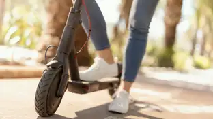 Mujer circulando en un patinete eléctrico Mujer circulando en un patinete eléctrico