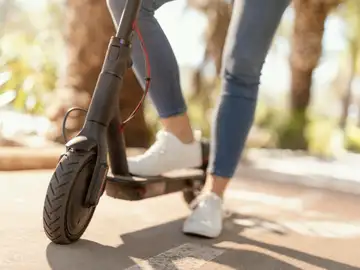 Mujer circulando en un patinete eléctrico Mujer circulando en un patinete eléctrico