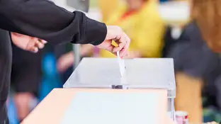 Imagen de una persona metiendo una papeleta en una urna Imagen de una persona metiendo una papeleta en una urna
