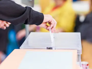 Imagen de una persona metiendo una papeleta en una urna Imagen de una persona metiendo una papeleta en una urna