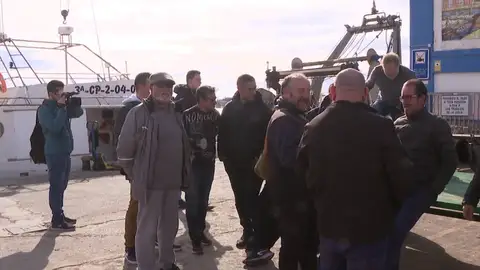 Varios pescadores hablando en un puerto español