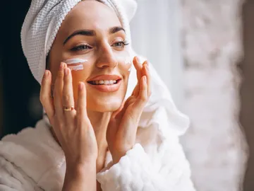 Mujer aplicándose un cosmético Mujer aplicándose un cosmético