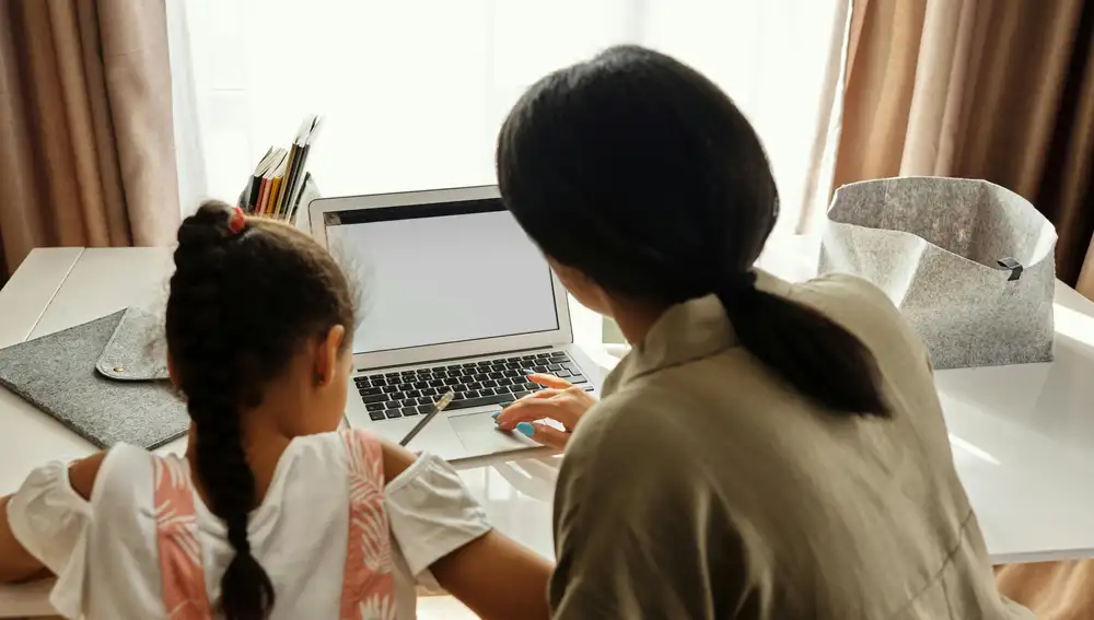 Madre ayudando a su hija a navegar por internet