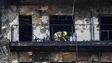 Un bombero inspeccionando en el edificio incendiado