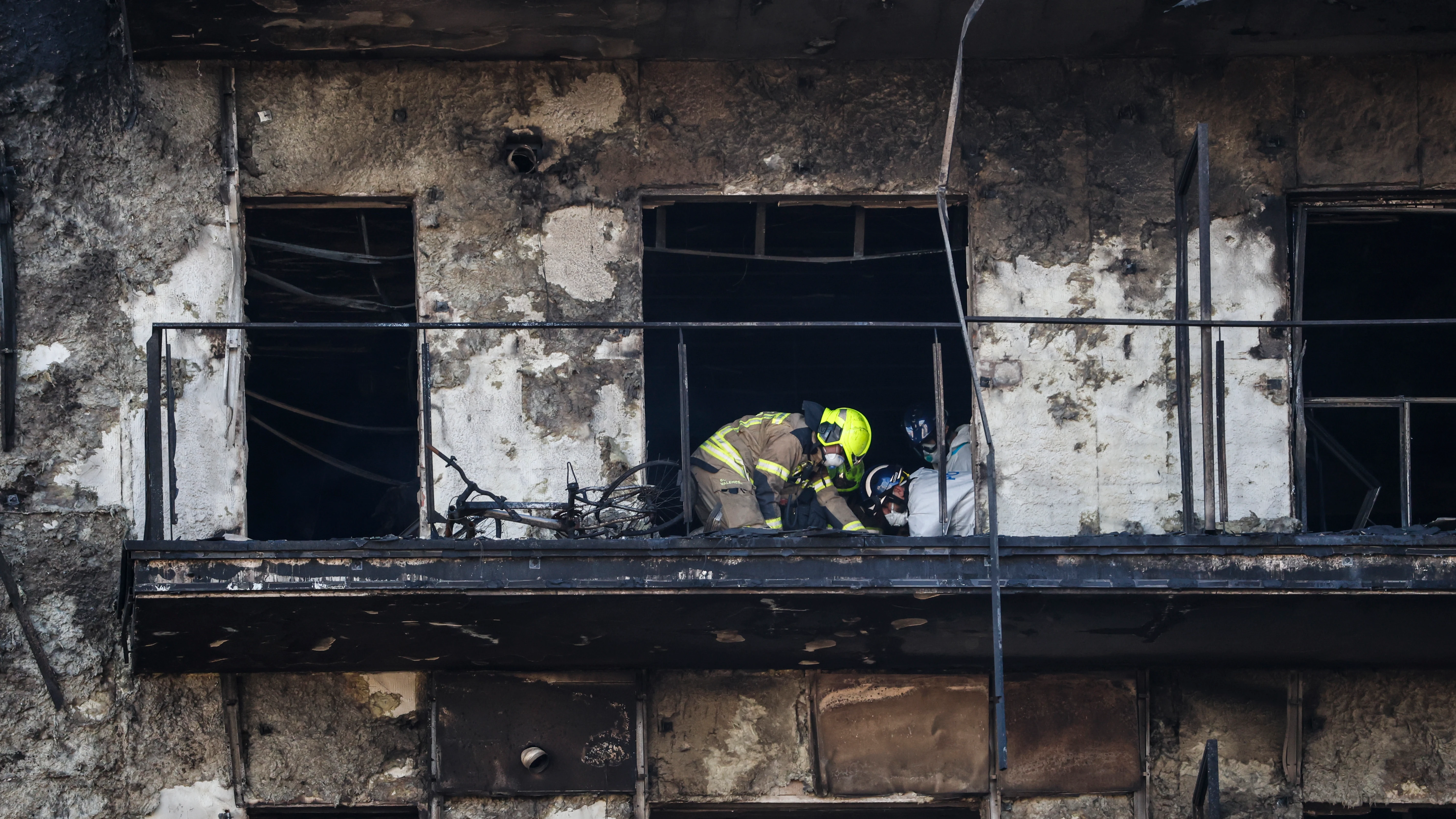 Un bombero inspeccionando en el edificio incendiado Un bombero inspeccionando en el edificio incendiado