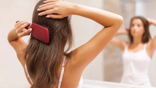 Mujer pein&aacute;ndose el cabello