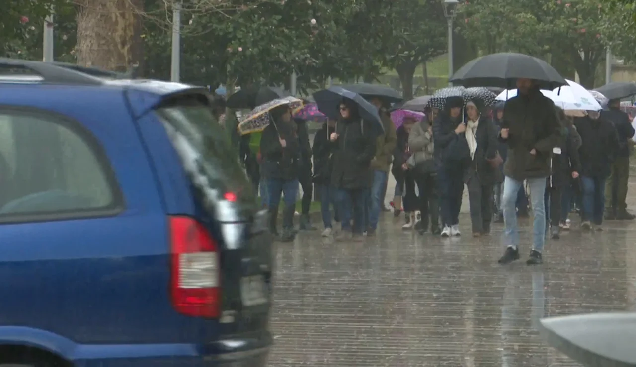 Gente con paraguas entre la lluvia