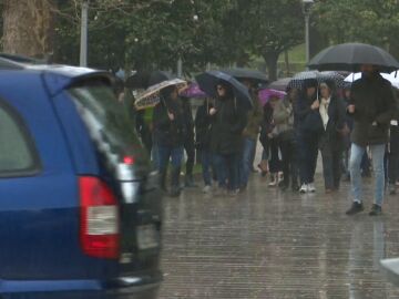 Gente con paraguas entre la lluvia