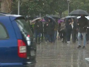 Gente con paraguas entre la lluvia Gente con paraguas entre la lluvia