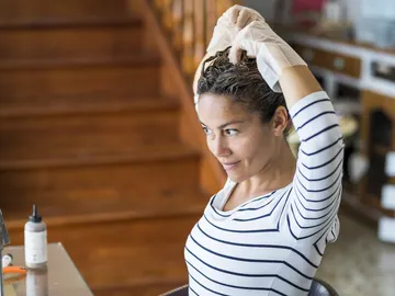 Mujer aplicándose tinte Mujer aplicándose tinte