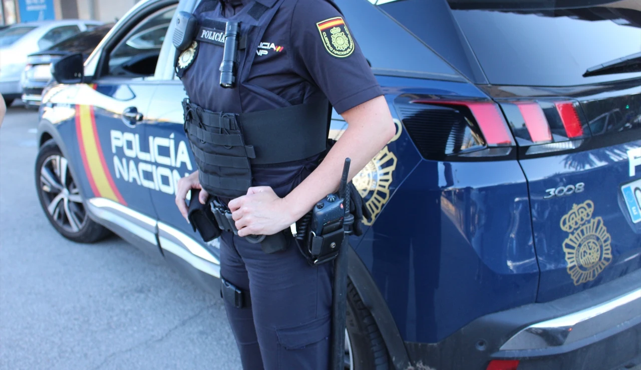 Imagen de archivo de un Policía Nacional junto al coche