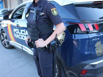 Imagen de archivo de un Policía Nacional junto al coche Imagen de archivo de un Policía Nacional junto al coche