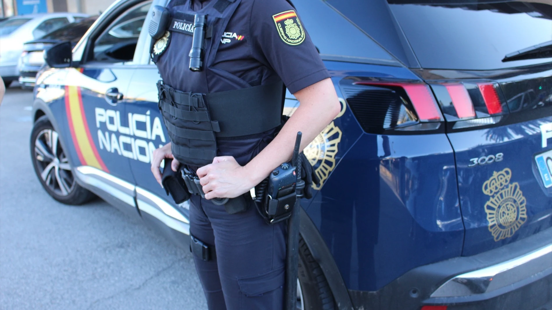 Imagen de archivo de un Policía Nacional junto al coche Imagen de archivo de un Policía Nacional junto al coche